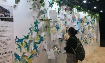 A visitor views a wall covered with written pleas for a biodiverse future at the Nature Positive Pavilion.