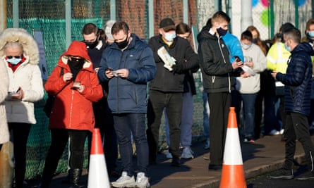 Members of the public queue at a mass-testing site at the Liverpool tennis centre in Wavertree.