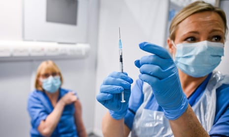 A nurse giving a fellow healthcare worker the Covid vaccine in Glasgow in December 2020.