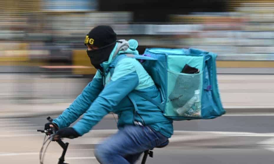 Deliveroo rider cycles through central London