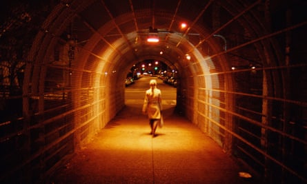 Woman crossing overpass at night