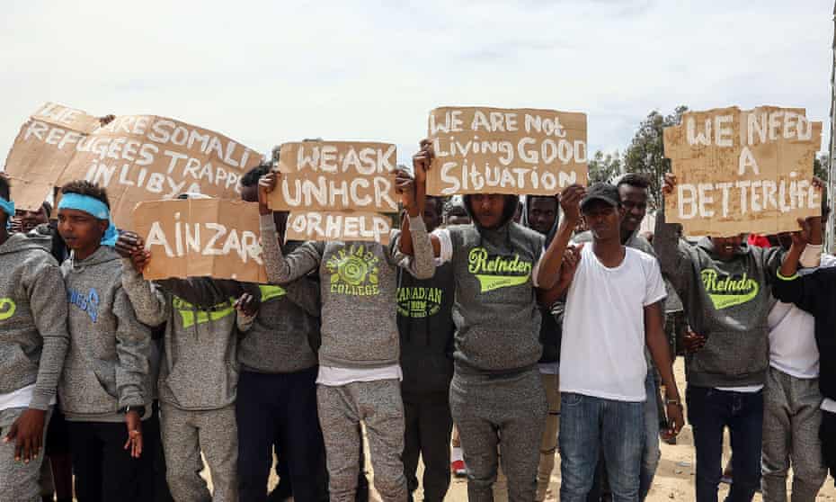 Migrants hold placards during the visit of António Guterres, the UN secretary general, to Ain Zara detention centre for migrants in the Libyan capital Tripoli