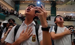 Local residents sing a theme song written by protesters "Glory to Hong Kong" at a shopping mall in Hong Kong in 2019