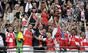 Arsenal’s players celebrate with the trophy.