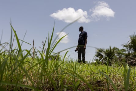 Un agriculteur se découpant sur le ciel dans un champ d'herbe