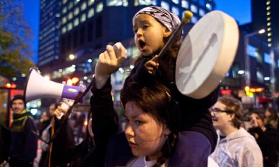 A girl plays the drums as she sings a traditional First Nations song during the demonstration on Saint Catherine street, downtown Montreal in support of the Mikmaq people of Elsipogtog First Nations in New Brunswick.