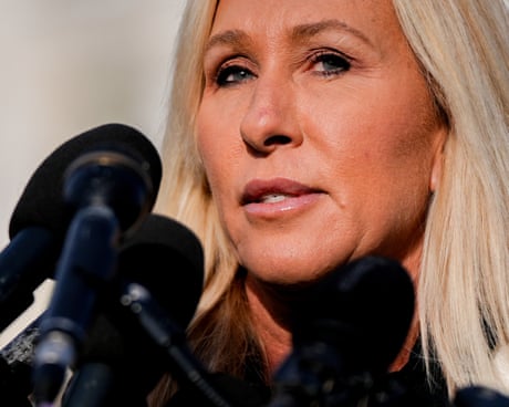 A woman speaks into microphones.