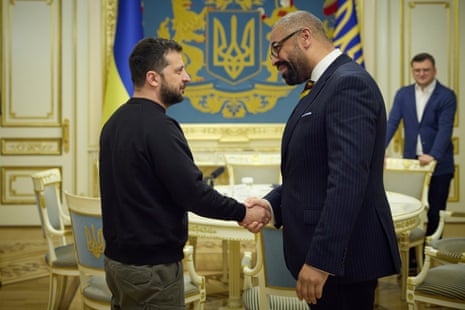 Volodymyr Zelenskiy, left, shakes hands with James Cleverly in Kyiv on Monday