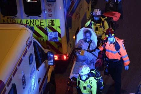 Paramedics rushing a woman on a stretchered to an ambulance as a major fire engulfs several residential buildings at Wang Fuk Court on November 27, 2025 in Hong Kong.
