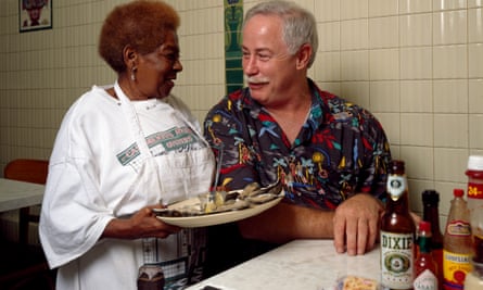 New Orleans writer and television personality Ronnie Virgets is served the house specialty, ice-cold oysters on the half shell, by Alma Griffin at Casamento Seafood Restaurant in Uptown New Orleans, Louisiana