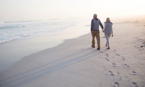 couple walking on beach in early morning leaving footprints behind them