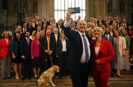 Davey and Cooper stand at the front, with Davey holding a phone camera, as the MPs stand behind them