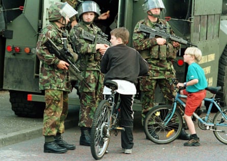 Young boys talk to British soldiers on the peace line in west Belfast, 1996