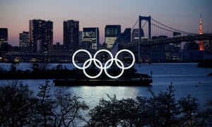 Un monument géant des anneaux olympiques est illuminé au crépuscule au parc marin d'Odaiba à Tokyo.