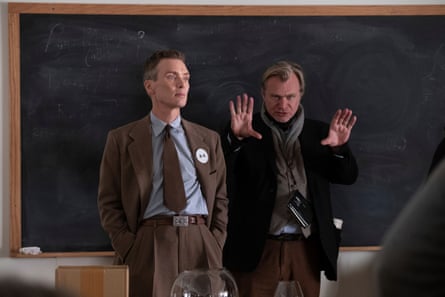 Christopher Nolan stretches out his hands to make a point to Cillian Murphy in front of a blackboard during the making of Oppenheimer