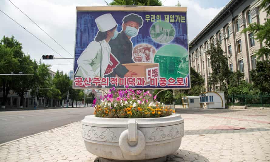 A poster displayed outside the Pyongyang Department Store No 1 on 27 May depicts people wearing face makes and reads ‘Displaying beautiful communist virtues and traits’.