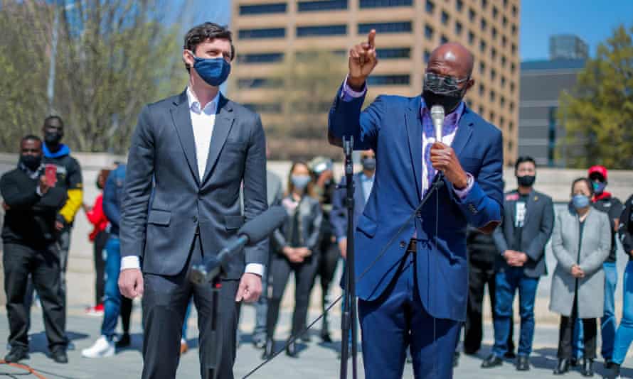 Les sénateurs américains Raphael Warnock, à droite, et Jon Ossoff participent à une marche et à un rassemblement au centre-ville d'Atlanta.