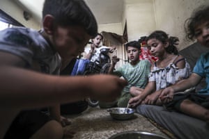 Palestinians, struggling with hunger due to the Israeli blockade, receive hot meals distributed by charity organisations in Jabalia refugee camp in Gaza City