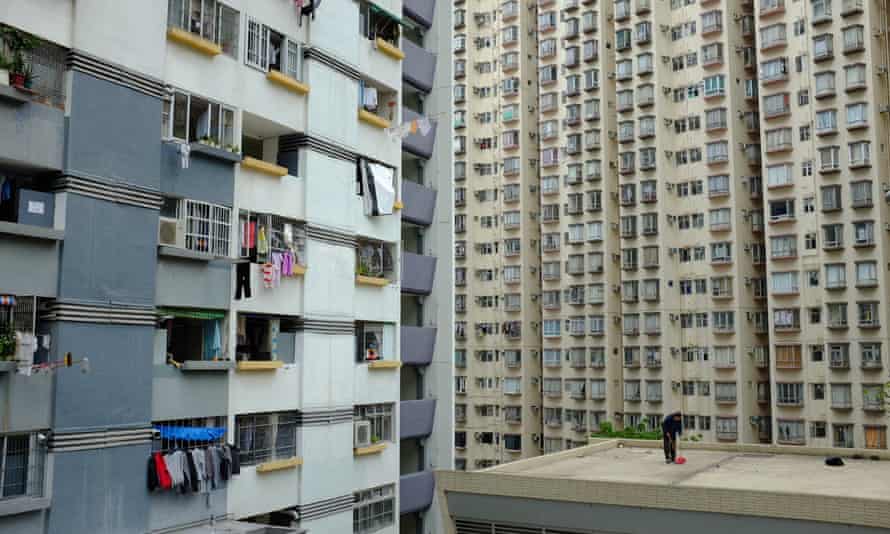 A cleaner is dwarfed by the buildings in Hong Kong