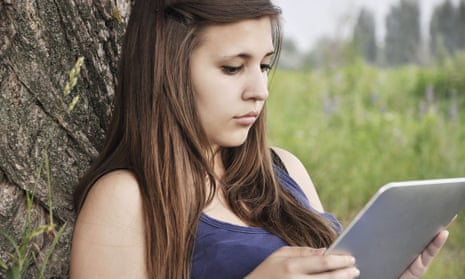 Teenage girl reading a book on a tablet