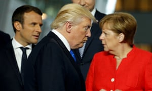 Donald Trump walks past French president Macron and German chancellor Merkel during a Nato summit. Trump withdrew the US from the Paris deal on Thursday.