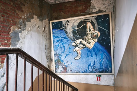 A mural of a cosmonaut outside a spacecraft above Earth