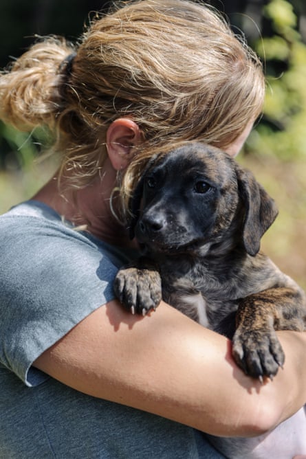 woman holds a puppy in the care of the Mendocino Coast Humane Society.