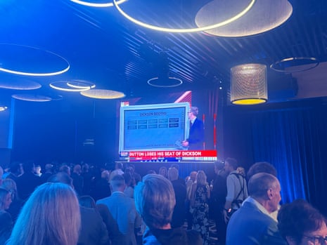 The ABC’s announcement that Peter Dutton has lost his seat dominates the big screen at Coalition HQ in Brisbane.