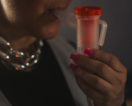 A woman holds a nebulizer