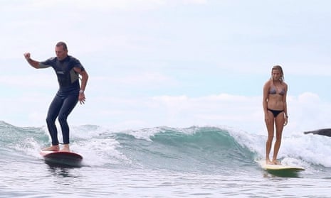 Tony Abbott surfs beside Ivy Thomas at Tea Tree Bay near Noosa