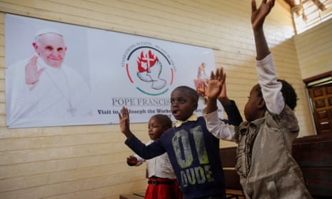 Kenyan children sing in front of a banner welcoming Pope Francis at a church in Nairobi.