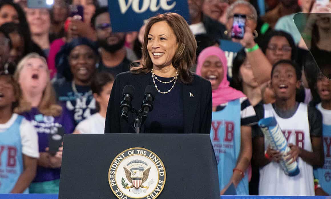 Kamala Harris smiles as she stands behind a podium on stage in Philadelphia