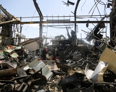 people walk through a destroyed university building