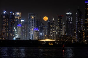 The full moon rises over the Dubai skyline.