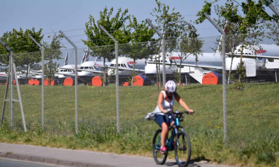 a cyclist passes grounded BA planes