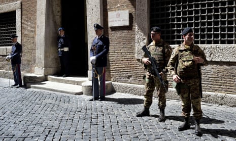 Police officers and soldiers stand guard outside the Italian national anti-mafia services HQ in Rome. 