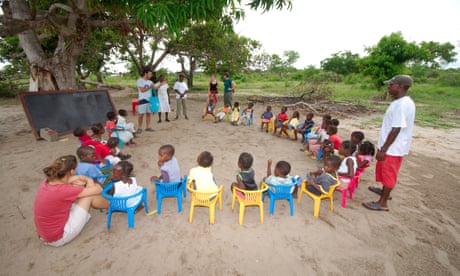 Volunteers help teach an outdoor class of schoolchildren in rural Mozambique