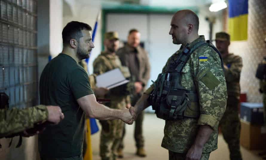 The Ukrainian president, Volodymyr Zelenskiy, shaking hands with a serviceman during his visit to the frontline positions of the army in Bakhmut and Lysychansk districts