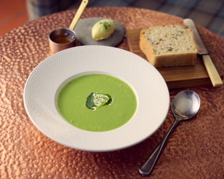 Bowl of (green) soup, served with bread and butter, on a copper-coloured table at the Riverside, an inn in Aymestrey, Herefordshire