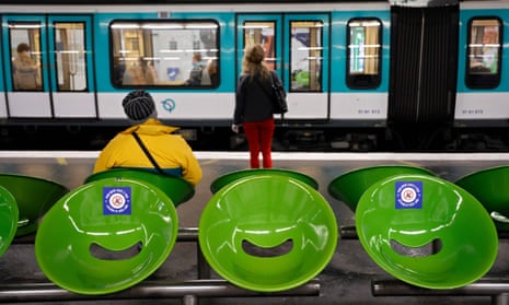 Stickers reading ‘for our health, leave this seat free’, are displayed on the seats as commuters wait for the metro in Paris.