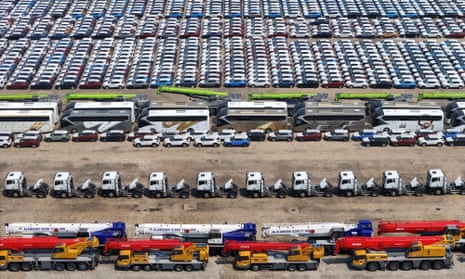 Large number of cars and construction machinery ar parked, waiting to be shipped for export