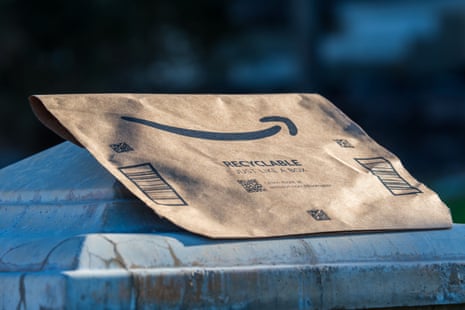 A brown paper Amazon mailer bag rests atop a rounded bin lid