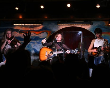 Shania Twain holding a guitar on stage