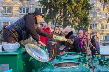Volunteers distribute hot food to internally displaced people at a street of Kharkiv.