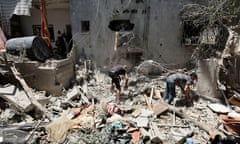 People look through rubble of a house destroyed in an Israeli strike