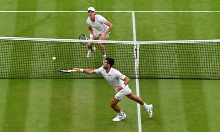Novak Djokovic plays a shot at the net against Jannik Sinner in the Wimbledon semi-final