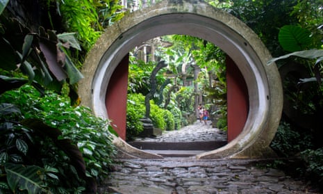 Circular tunnel-like sculpture amid verdant foliage in Las Pozas sculpture garden, Mexico