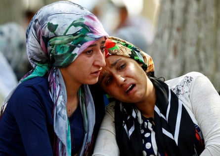 Women mourn as they wait in front of a hospital morgue