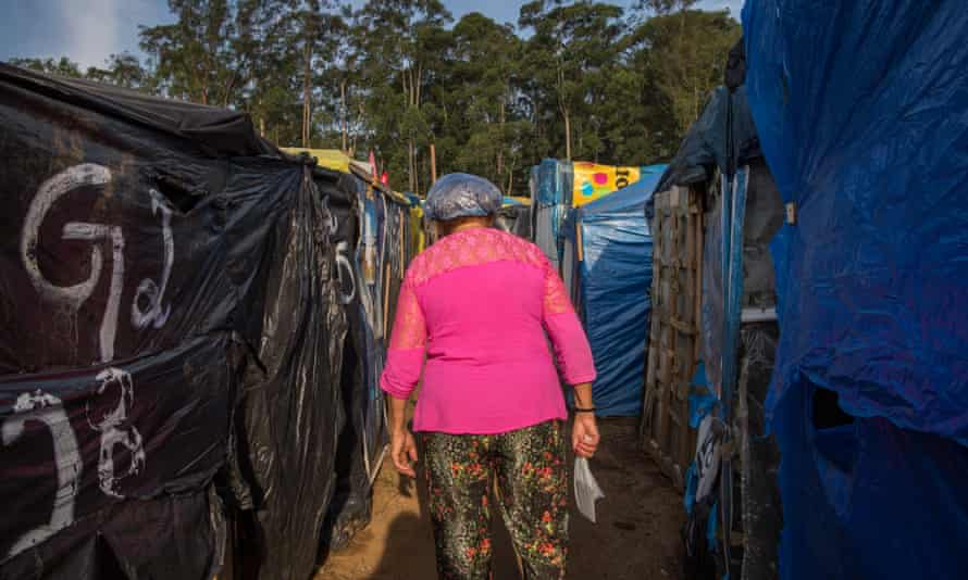 An occupant who works in the kitchen walks among the tents to get supplies