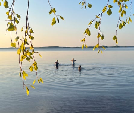 Three people standing in a lake.